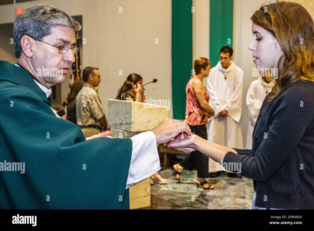 Miami Florida,Hialeah Immaculate Conception Catholic Church,Hispanic congregation altar service priest wafer communion man woman female offering, Stock Photo