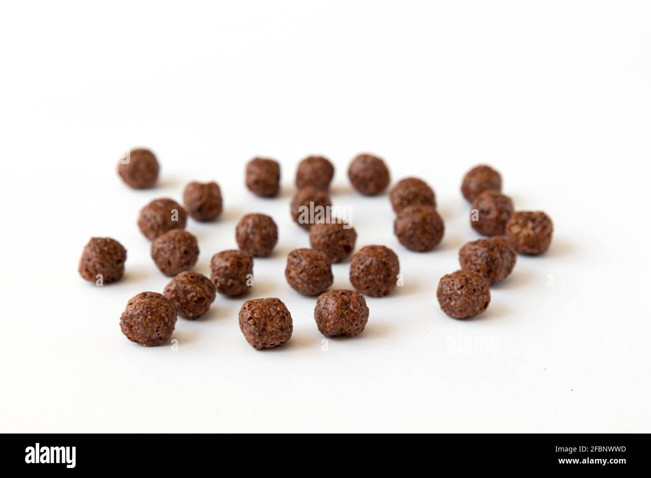 crunchy chocolate cereal balls isolated on white background, dry breakfast chocolate flavored balls Stock Photo