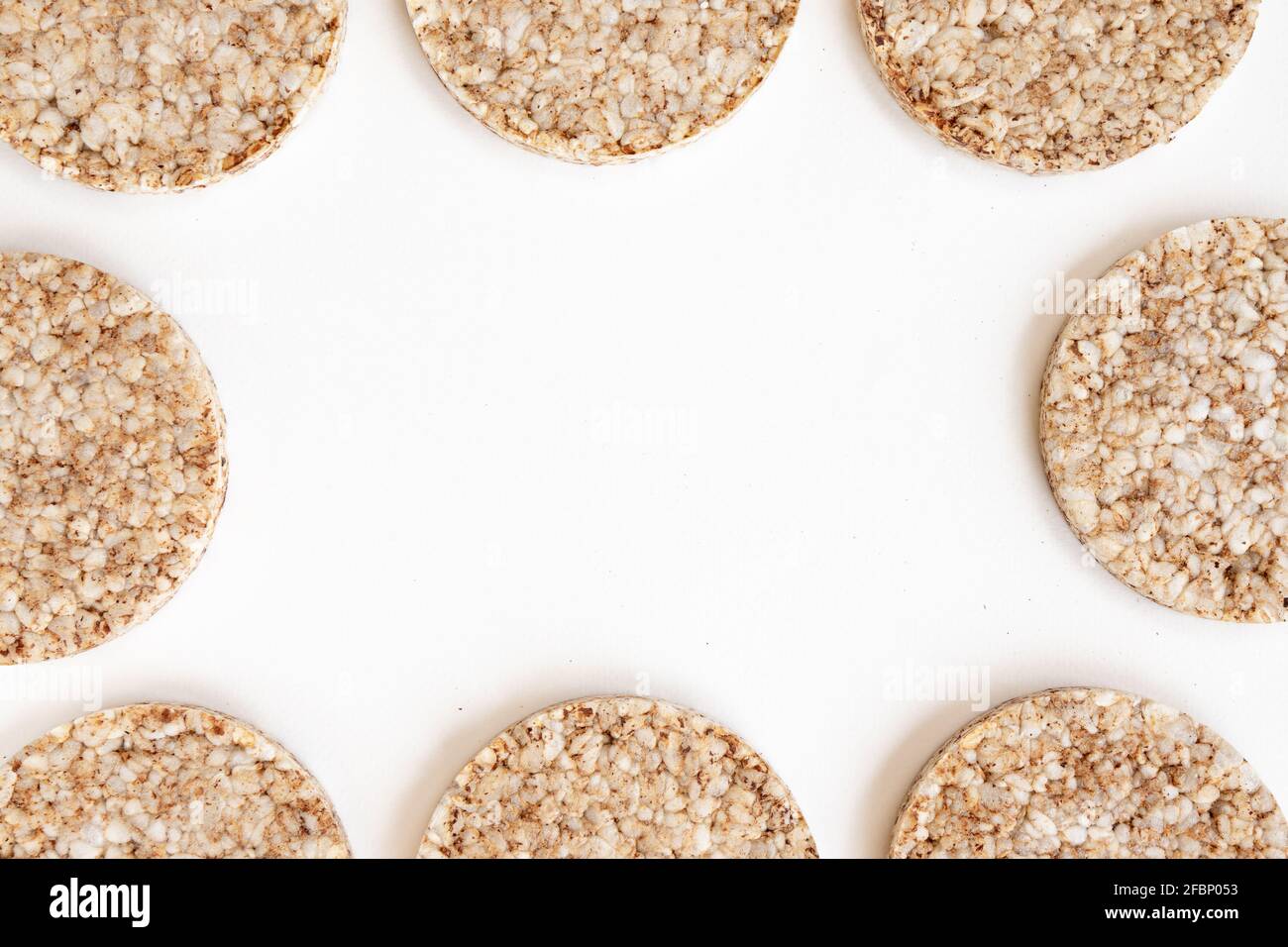 crunchy rice cakes isolated on white background, frame of puffed whole grain crispbread and empty space for text, close up Stock Photo