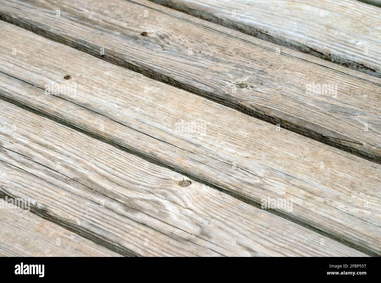 The backyard deck is beginning to look old and weathered and could use a good coat of sealer. It makes a nice texture or background with a slight boke Stock Photo
