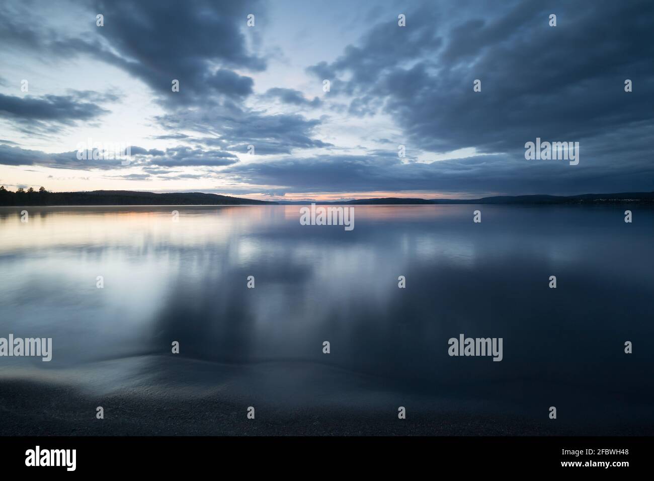 Beach of a calm swedish lake photographed in twilight Stock Photo