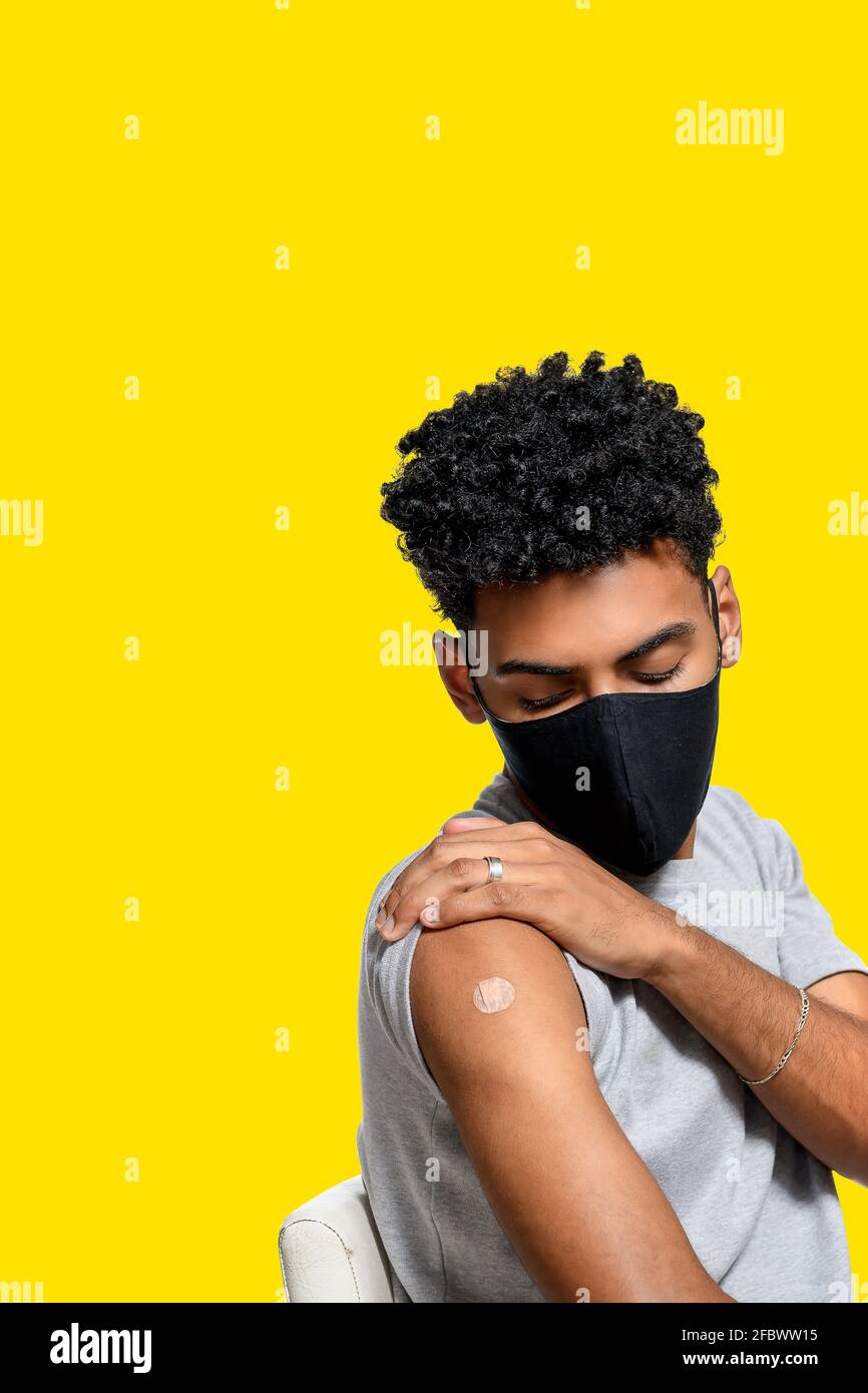 adolescent shows patch after receiving immunization , vaccination of adolescent isolated on yellow background Stock Photo