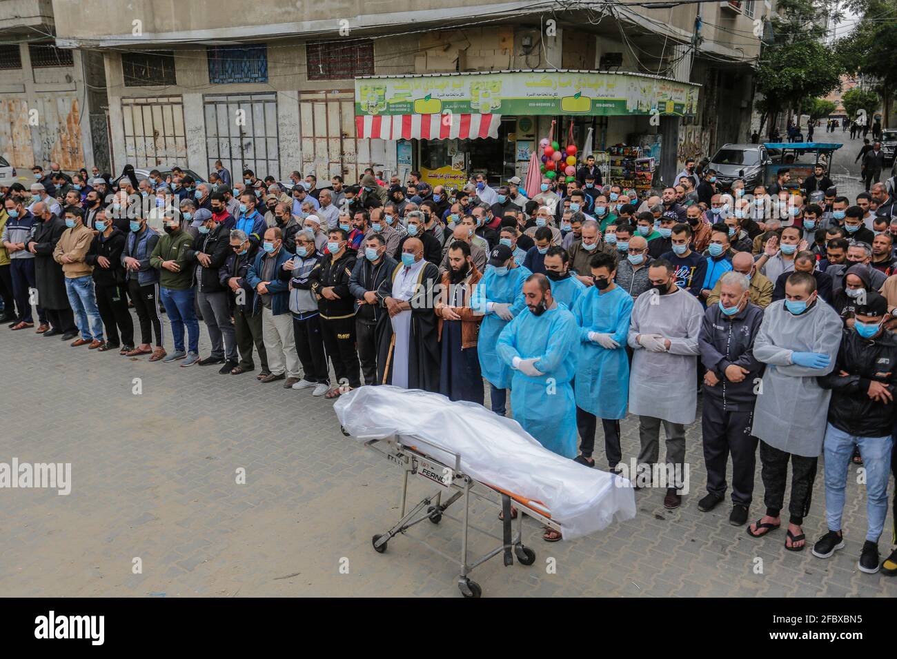 Gaza City, The Gaza Strip, Palestine. 23rd Apr, 2021. Palestinians perform funeral prayers for a man who died after being infected with the Coronavirus (Covid-19), as the victim's body was transported in an ambulance, at the Fallujah cemetery in the northern Gaza Strip. Credit: Mahmoud Issa/Quds Net News/ZUMA Wire/Alamy Live News Stock Photo