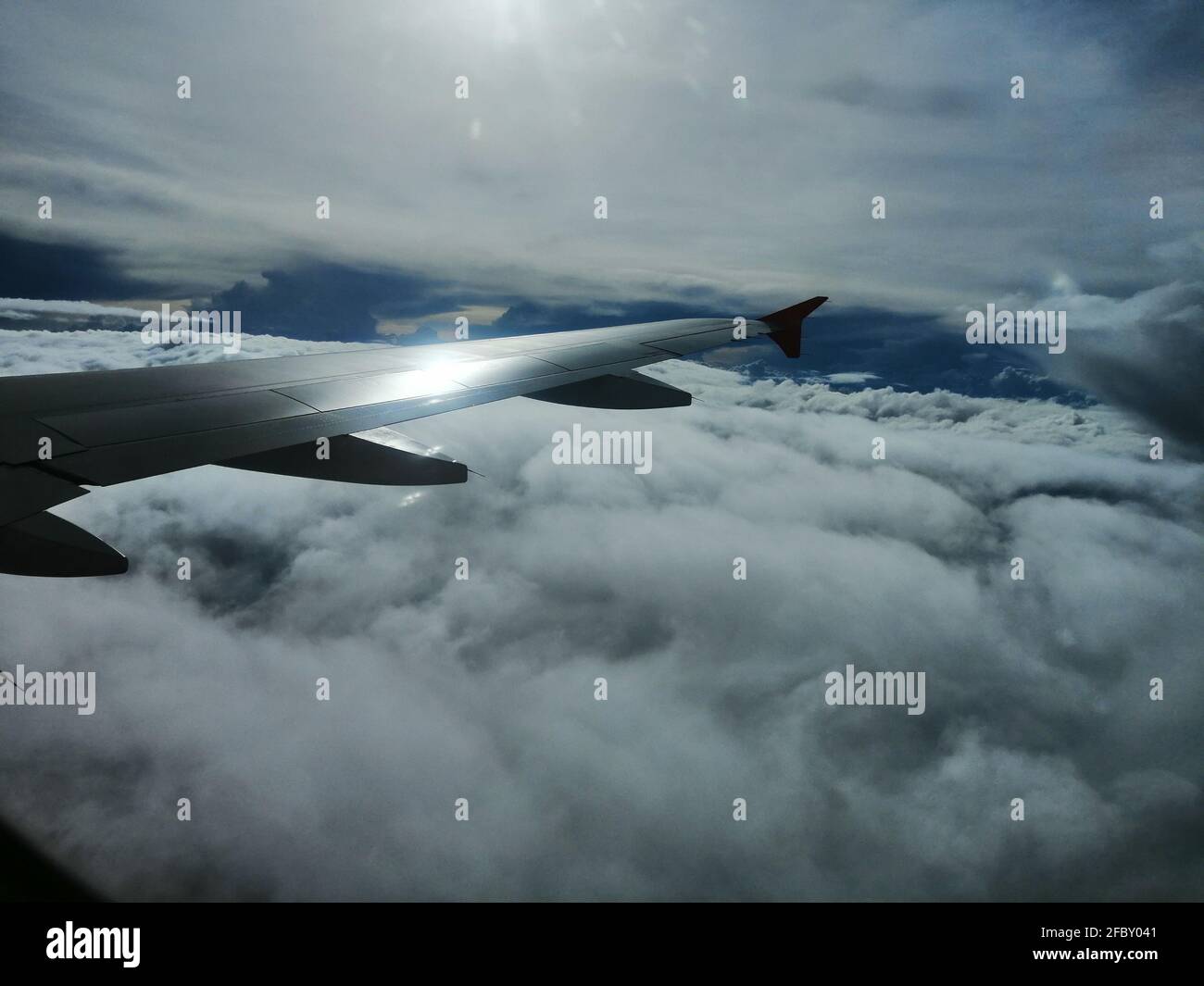 Wing of an airplane flying above the clouds Stock Photo - Alamy