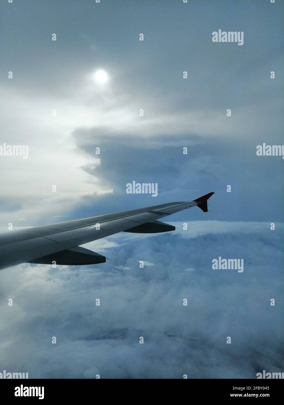 Wing of an airplane flying above the clouds Stock Photo - Alamy