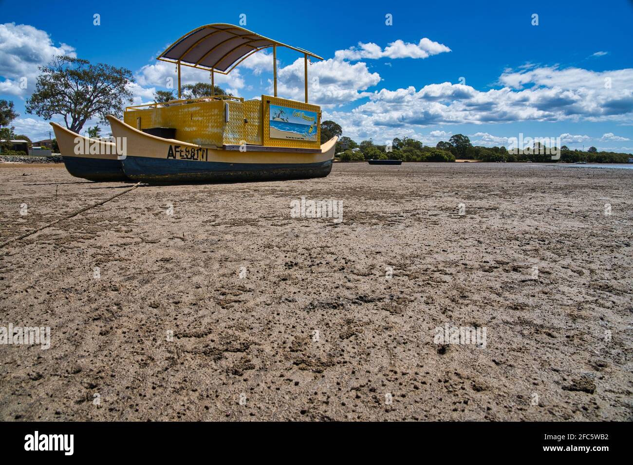 Yellow boat on the beach with a blue sky Stock Photo - Alamy