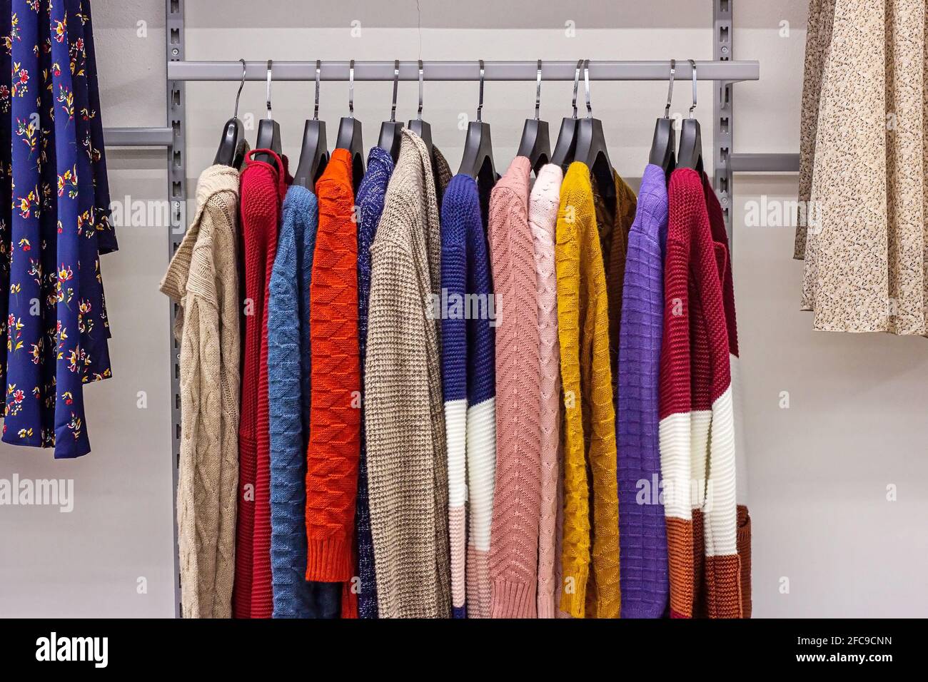 Different casual clothes hanging in the retail clothing store. Stock Photo