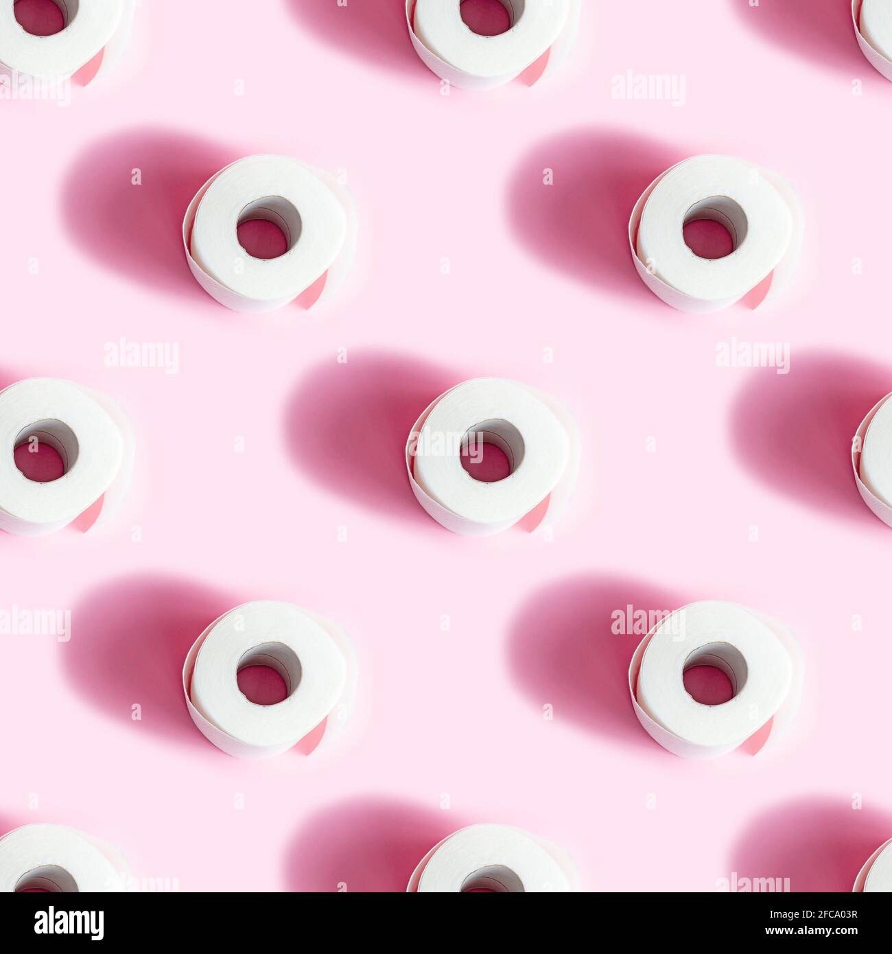 White toilet paper roll repeat seamless pattern on light pink background. Stock Photo