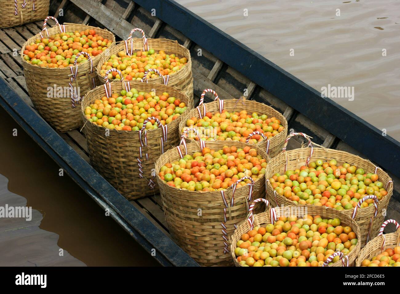 Baskets full of tomatoes in a boat for delivery to the market. Lake Inle, Myanmar. Stock Photo