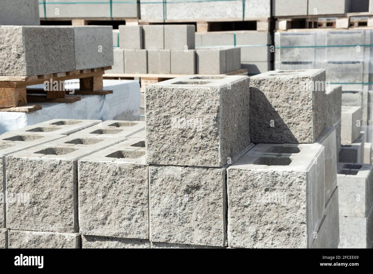 Stack of cement concrete Building cinder blocks brick  on pallete in hardware store with decorative stone texture side Stock Photo
