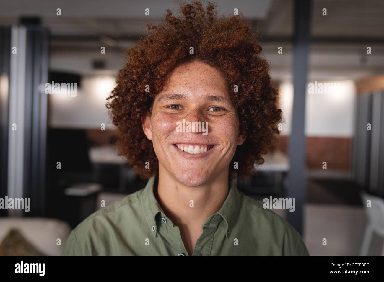 Portrait of happy mixed race businessman standing at the office room smiling Stock Photo