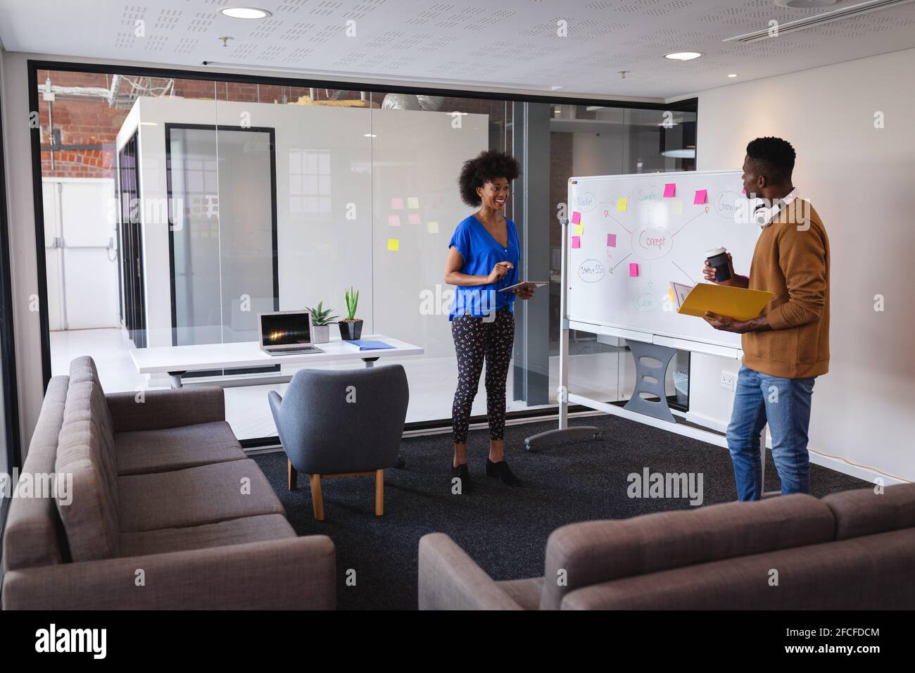 Diverse male and female colleagues standing in front of whiteboard ...