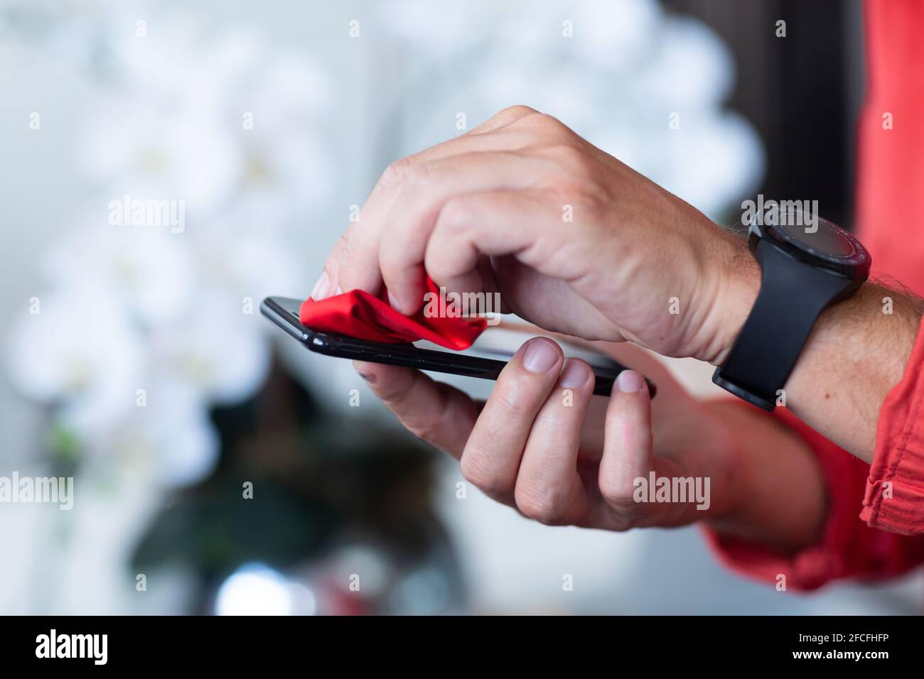 Midsection of businessman disinfecting smartphone with tissue Stock Photo