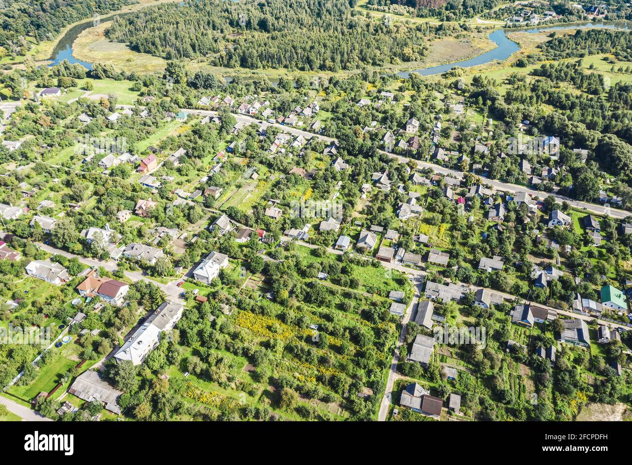 aerial panoramic view of a residential neighborhood with homes and trees near river on a spring sunny day Stock Photo