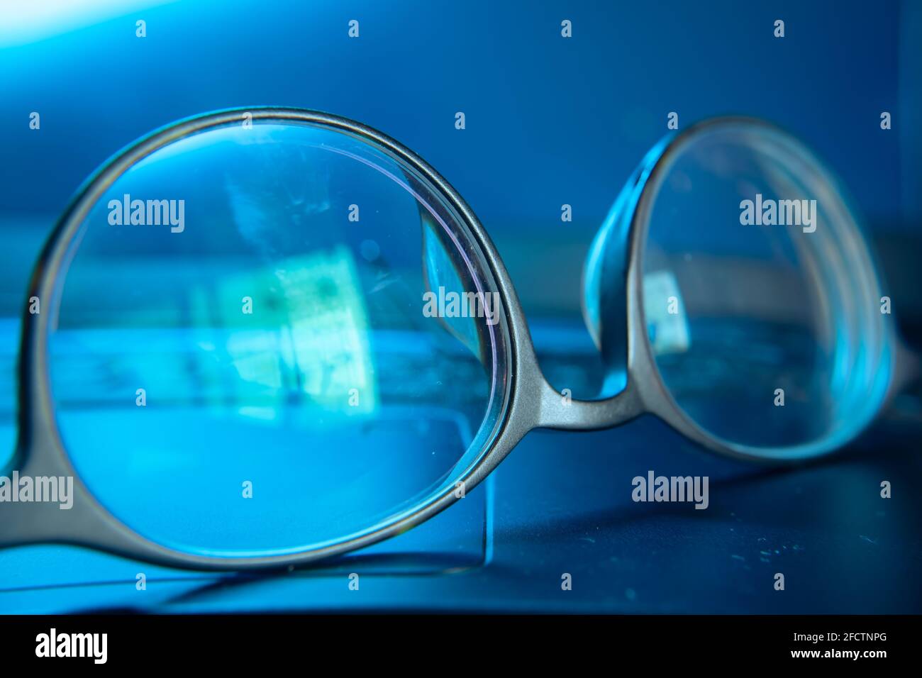 Eyeglasses in blue light from computer screen Stock Photo