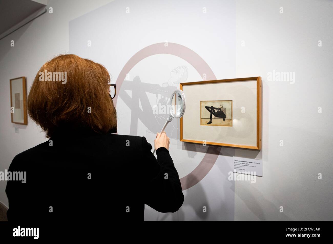 Vila Nova De Gaia, Portugal. 23rd Apr, 2021. Paula Carvalhal, Gaia Town Councillor of Culture uses a magnifying glass to look carefully at a caricature of Amadeo Souza-Cardoso during the exhibition.The exhibition, Drawings and caricatures by Amadeo de Souza-Cardoso were inaugurated in Casa-Museu Teixeira Lopes/Galerias Diogo de Macedo, the biggest museum in Gaia. Credit: SOPA Images Limited/Alamy Live News Stock Photo
