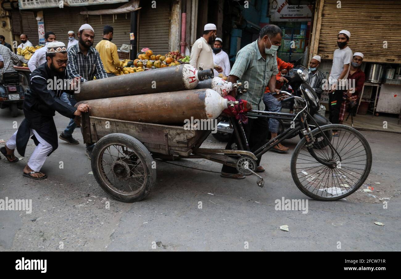 New Delhi, India. 23rd Apr, 2021. Family members of a Covid-19 infected patient push a hand cart with empty oxygen cylinders to refill at a oxygen filling center in Old Delhi. India is running out of oxygen during the second wave of Covid-19 pandemic. India has recorded 332,730 new Covid-19 cases in a single day and 2,263 deaths in the last one day. (Photo by Naveen Sharma/SOPA Images/Sipa USA) Credit: Sipa USA/Alamy Live News Stock Photo