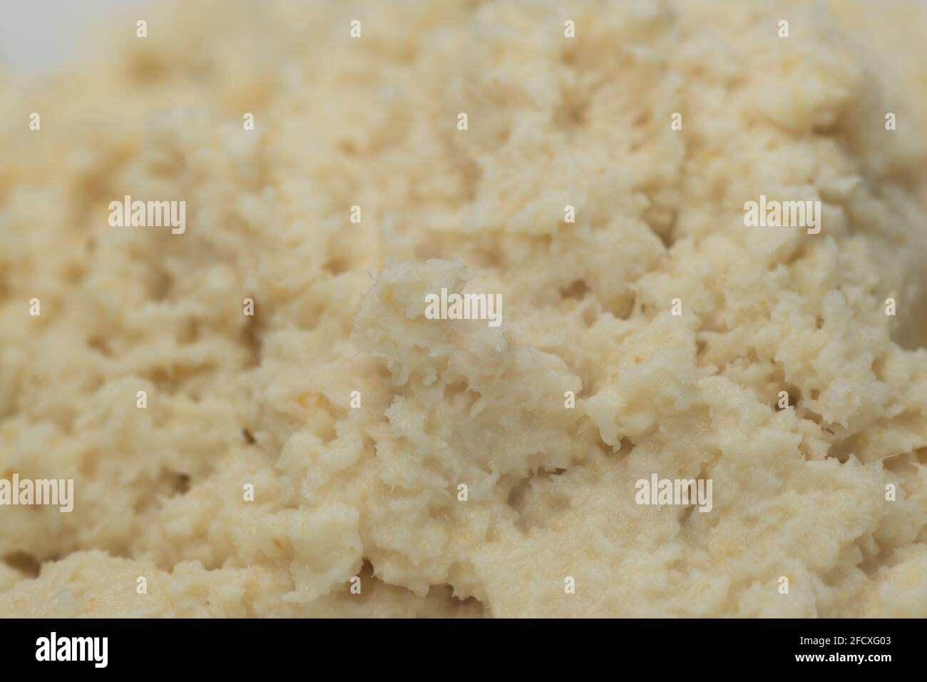 grated horseradish root on plate closeup selective focus Stock Photo