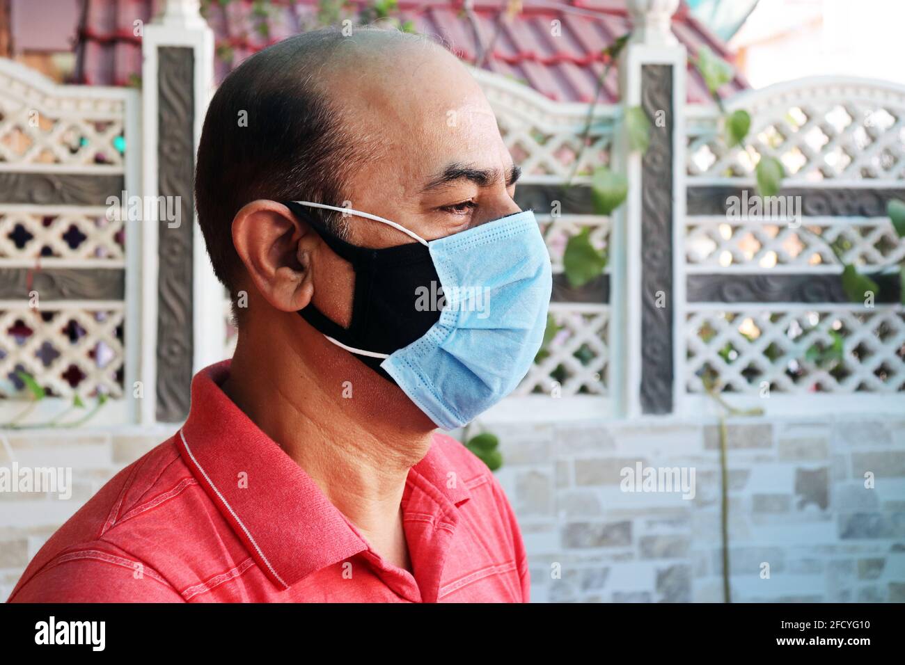 double mask prevent infection, mature indian man wearing two face mask to protect from new strain of coronavirus or new wave of covid-19 outbreak in i Stock Photo