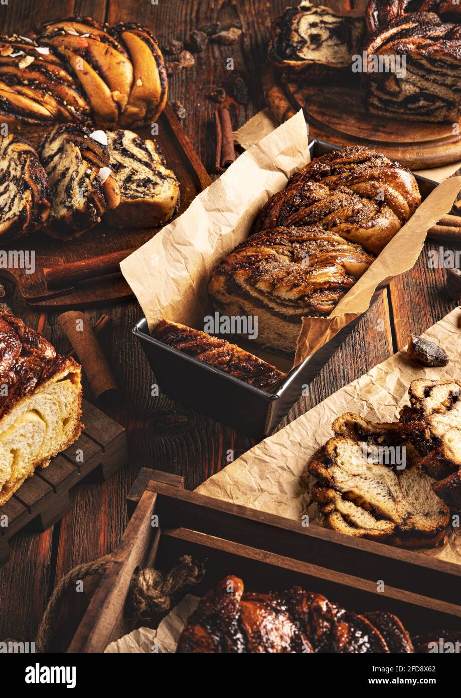 Still life of various type of babka sweet swirl sourdough bread on wooden background Stock Photo