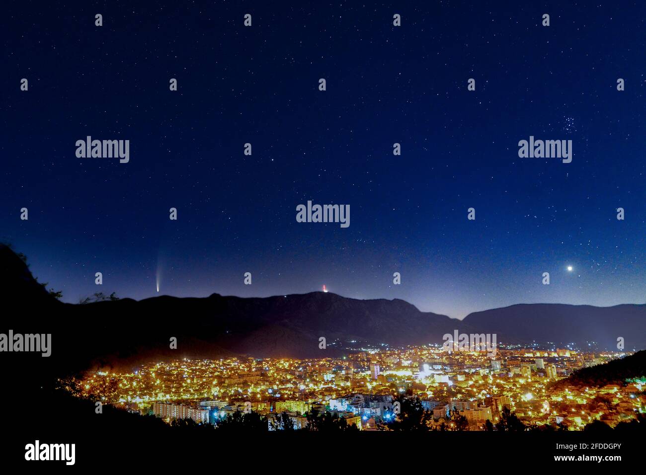 Comet falling in a night sky over a city Stock Photo