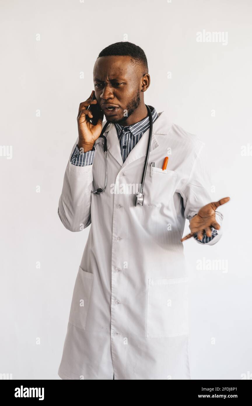 serious puzzled African American doctor talking on the phone. Doctor received bad news waiting hoping positive result. White background  Stock Photo