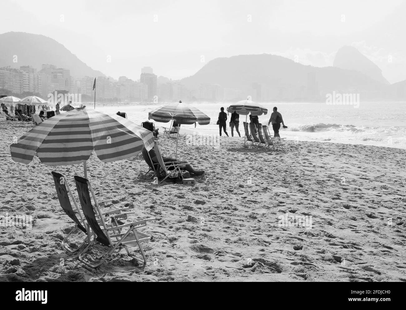 Monochrome image of group of people enjoy the activities on the sandy beach Stock Photo