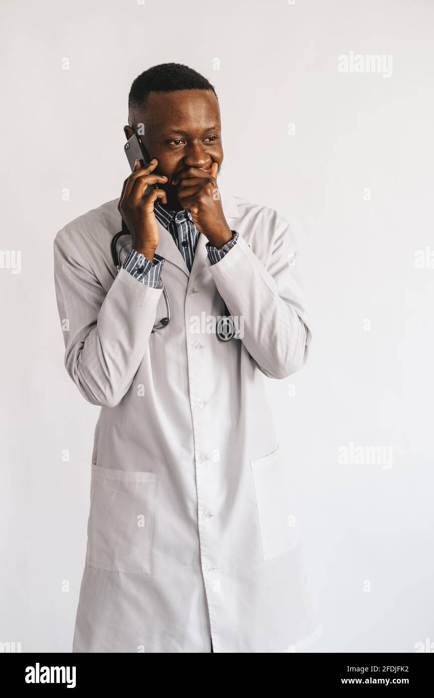 serious puzzled African American doctor talking on the phone. Doctor received bad news waiting hoping positive result. White background  Stock Photo