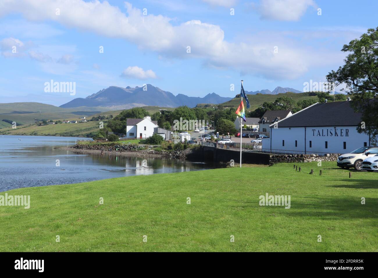 Talisker Distillery on the Isle of Skye with the Cuilin Mountains in the background. Stock Photo
