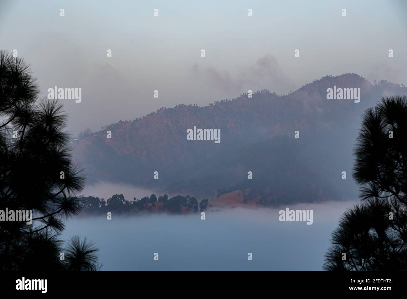 View of low and thick fog in a valley surrounded with mountains and ...