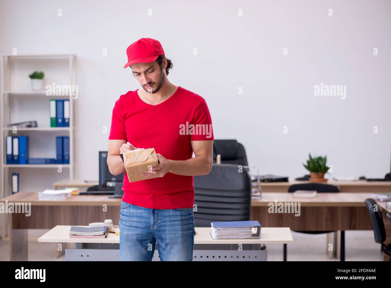 Young courier delivering post to the office Stock Photo Alamy