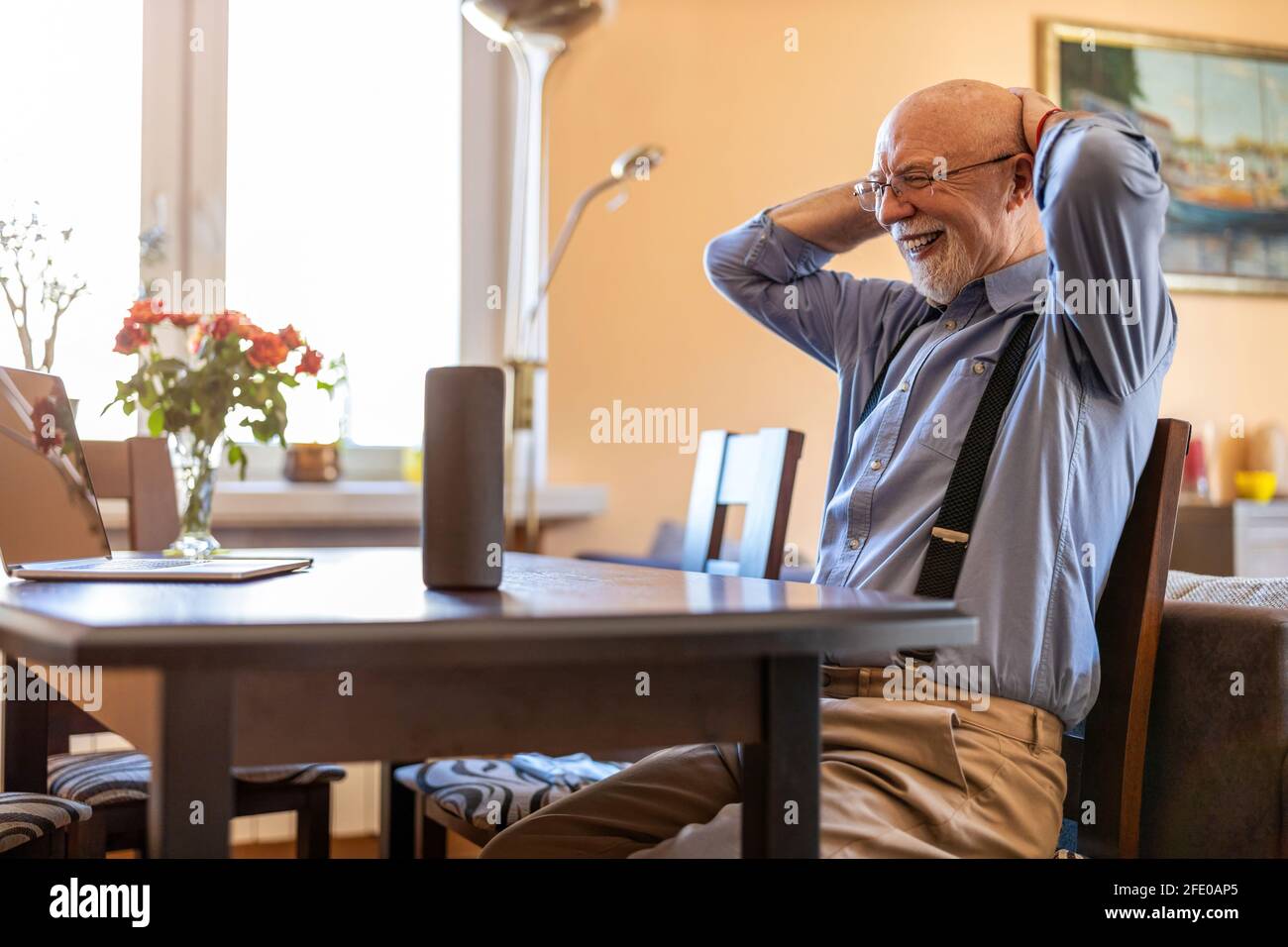 Senior man using Virtual Assistant at home Stock Photo