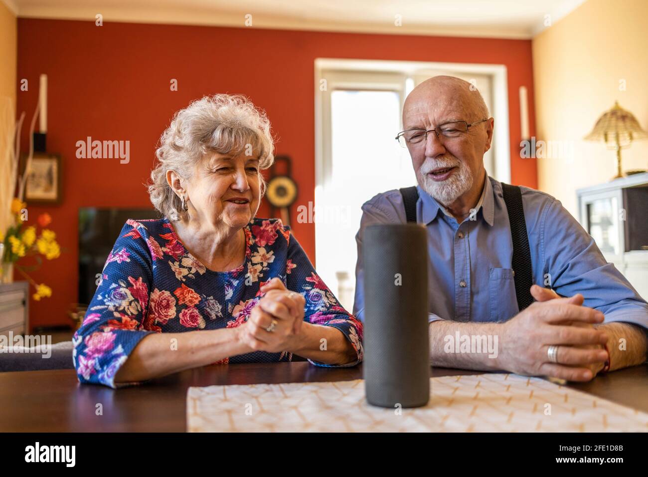 Excited senior couple using a Virtual Assistant at home Stock Photo