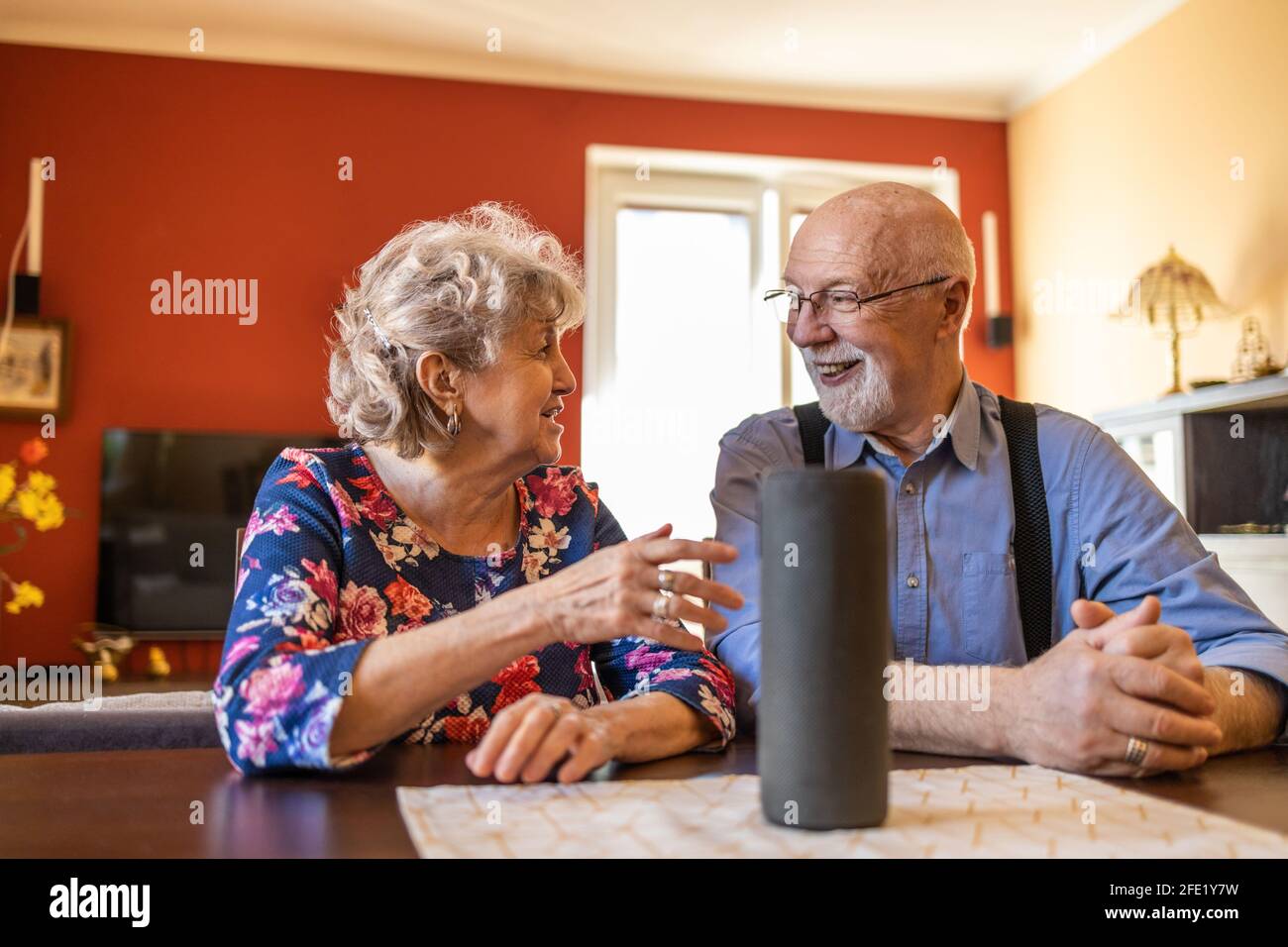 Excited senior couple using a Virtual Assistant at home Stock Photo