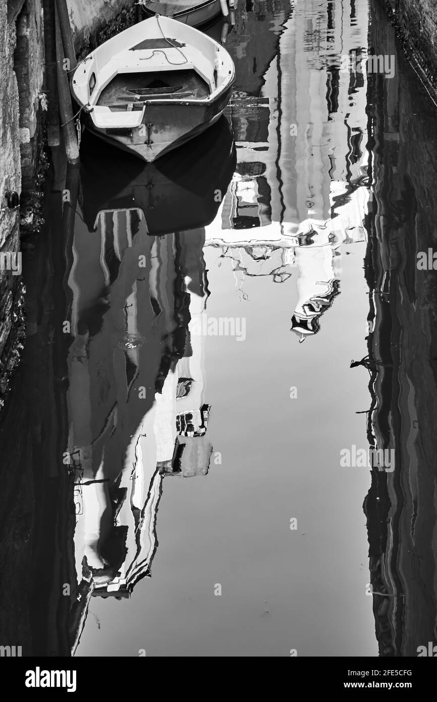 Canal in Venice, Italy. Water reflection of old buildings.  Black and white photography, venetian scenic view Stock Photo