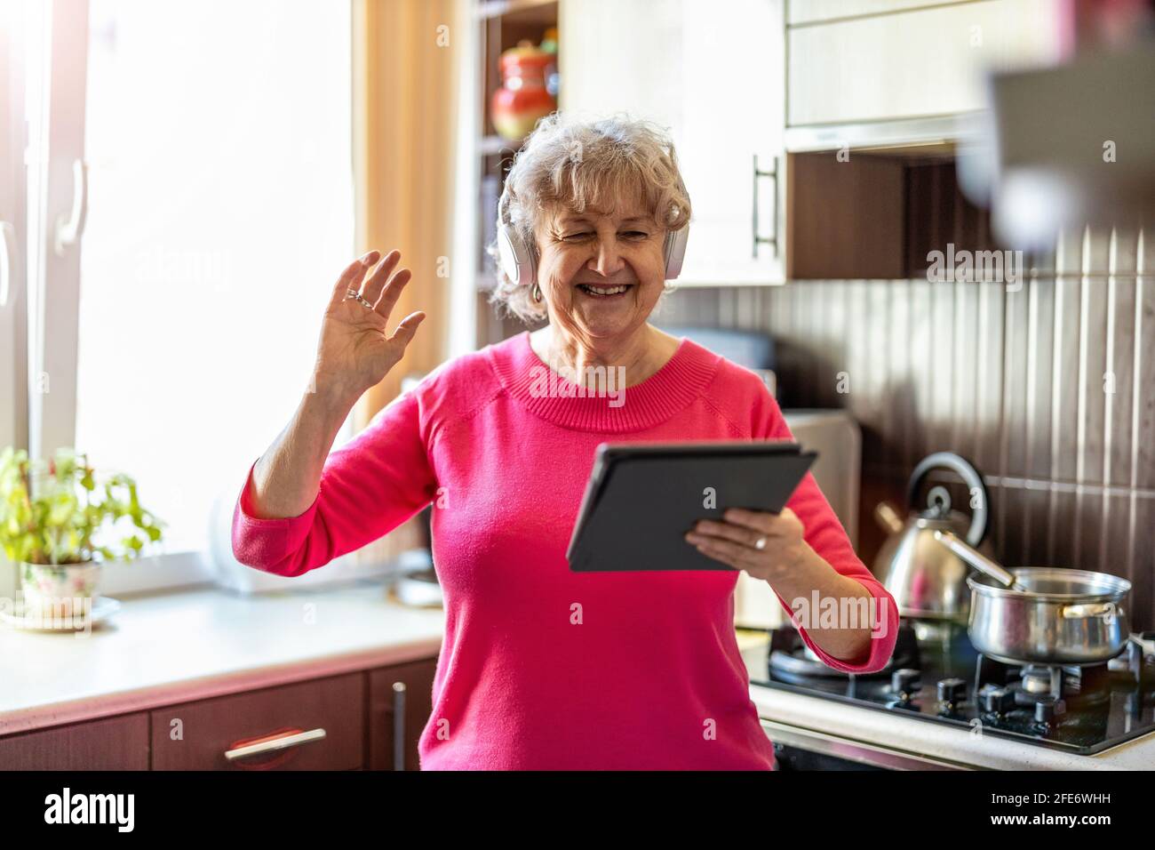 Happy senior woman using digital tablet at home Stock Photo