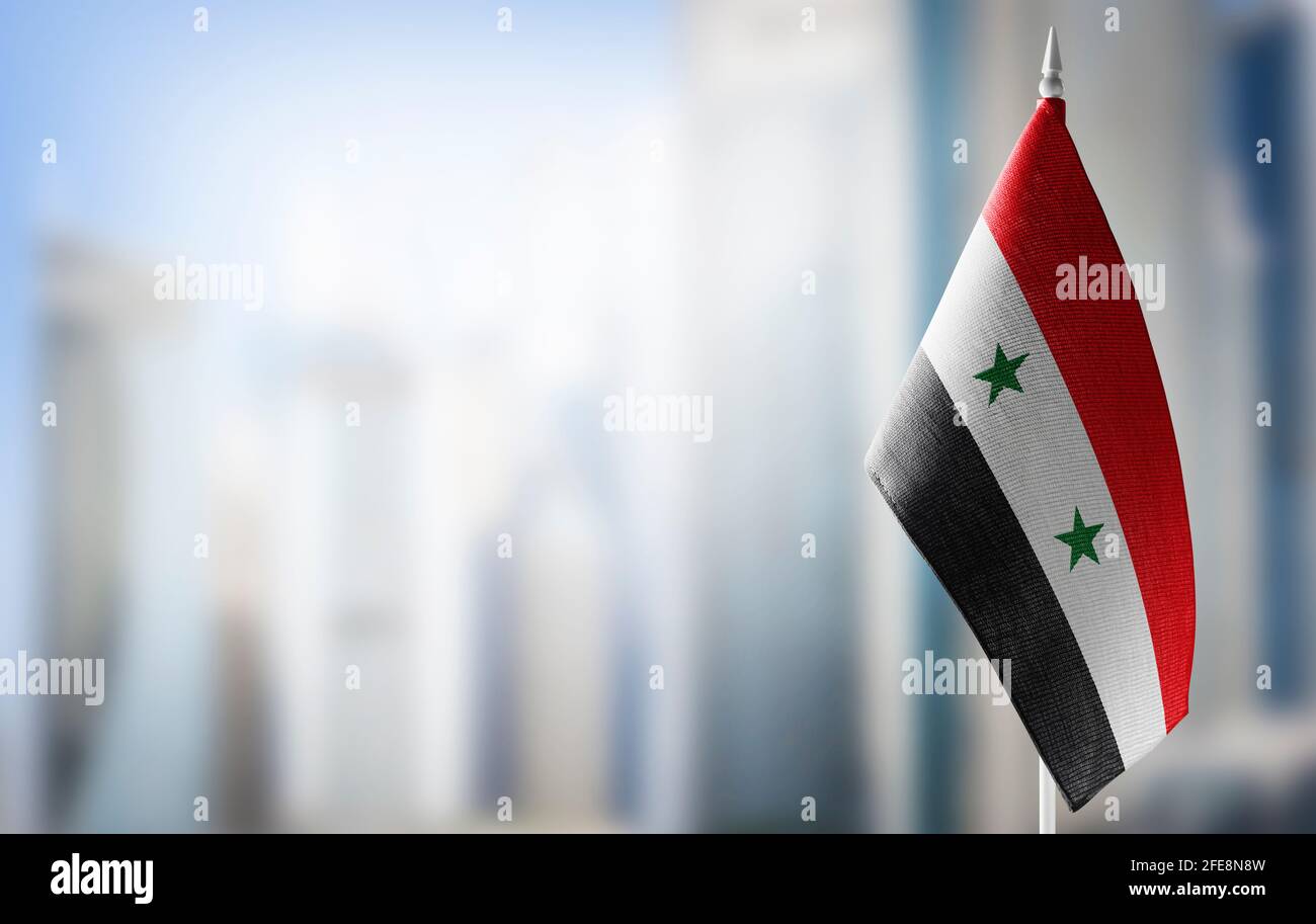 A small flag of Syria on the background of a blurred background Stock Photo  - Alamy
