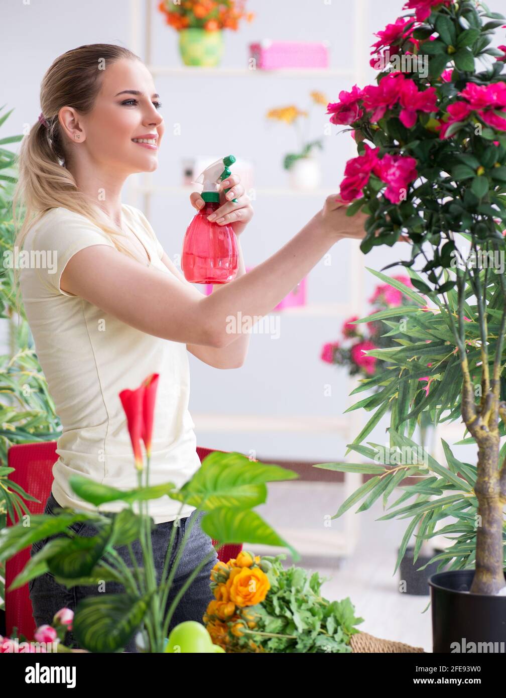 The young woman watering plants in her garden Stock Photo - Alamy