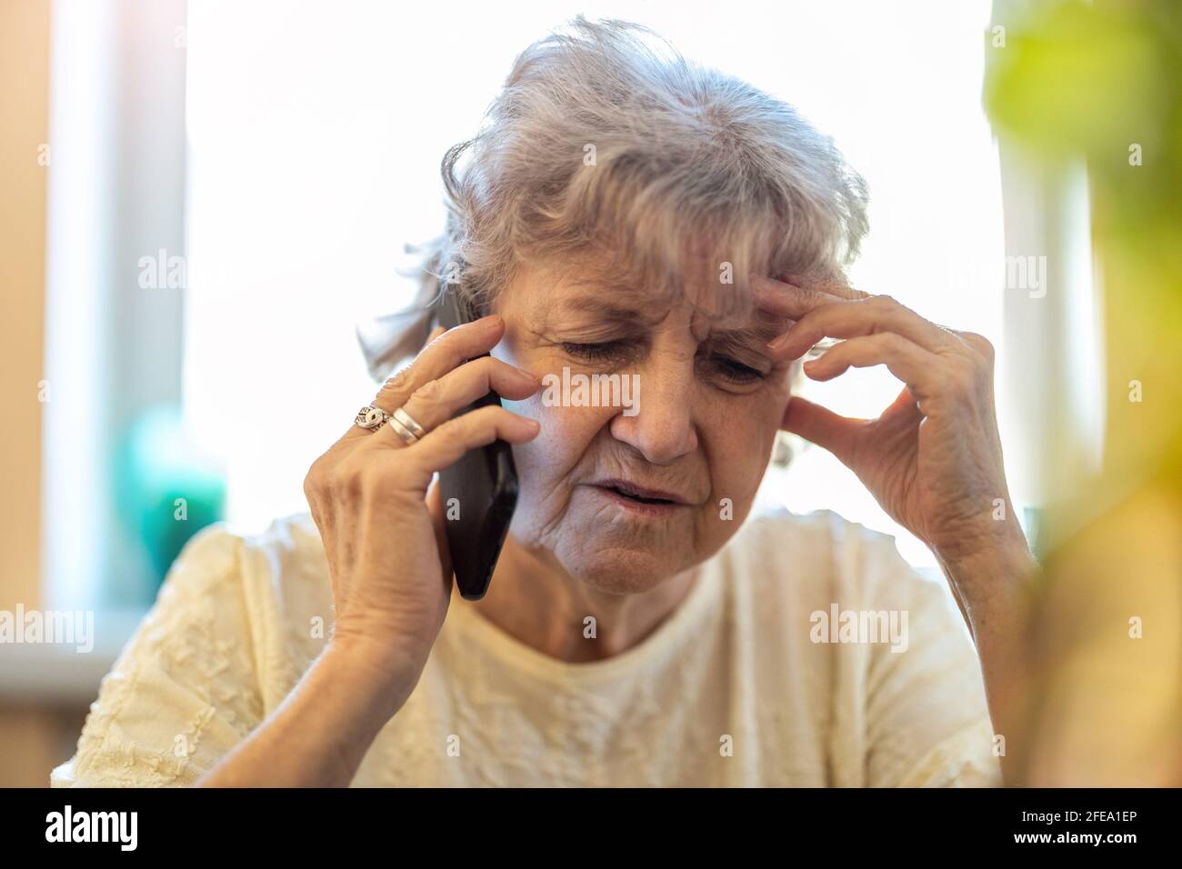 Shot of a tired senior woman using a mobile phone Stock Photo