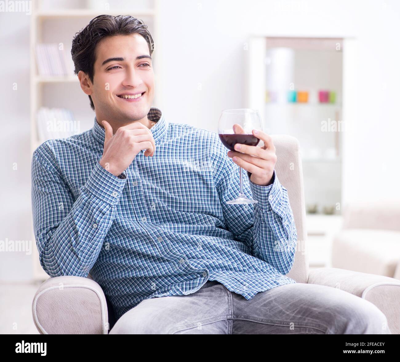 The young man drinking wine at home Stock Photo - Alamy