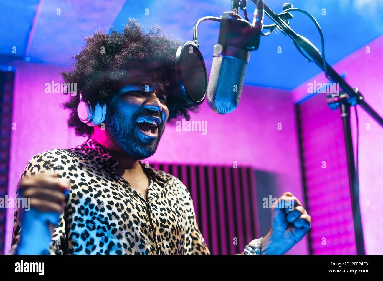 Young professional afro singer recording a new song album inside music production studio Stock Photo