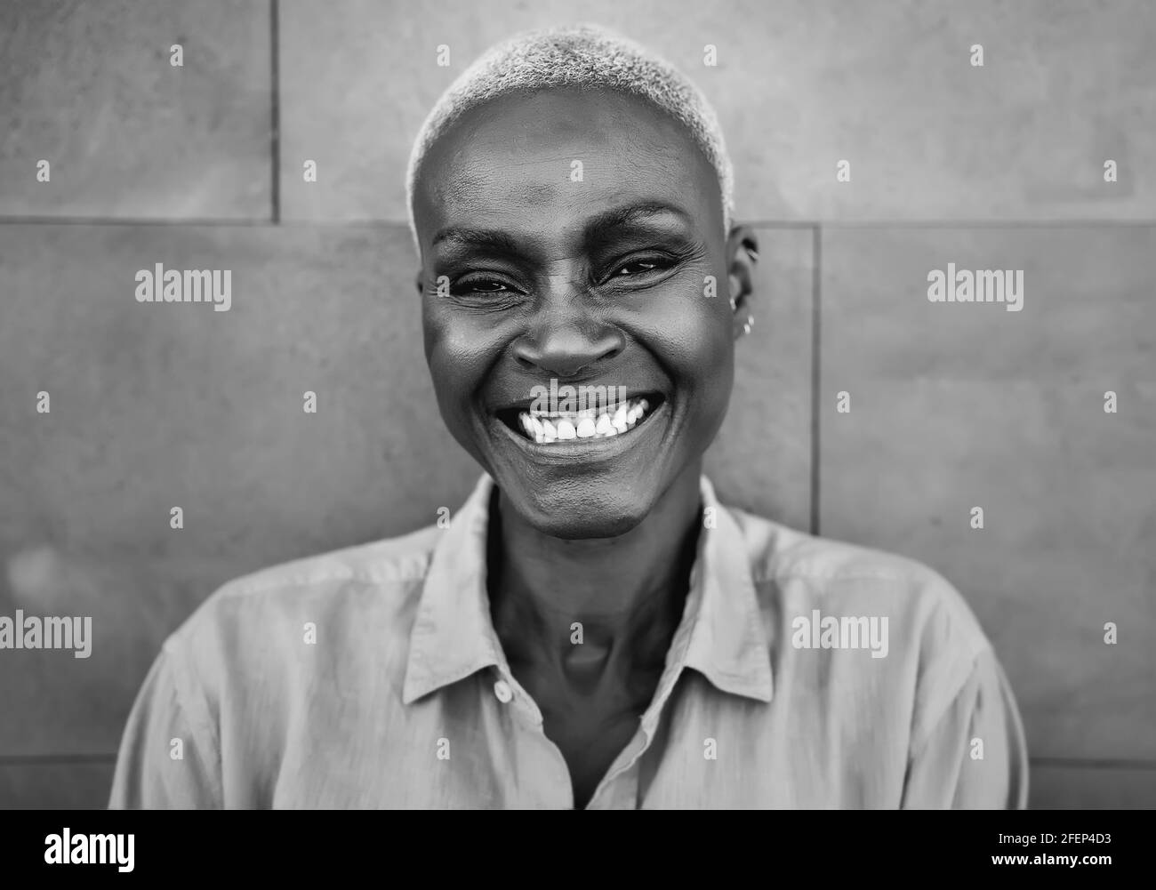 Happy Afro woman portrait - African senior female having fun smiling in front of camera - Black and white editing Stock Photo