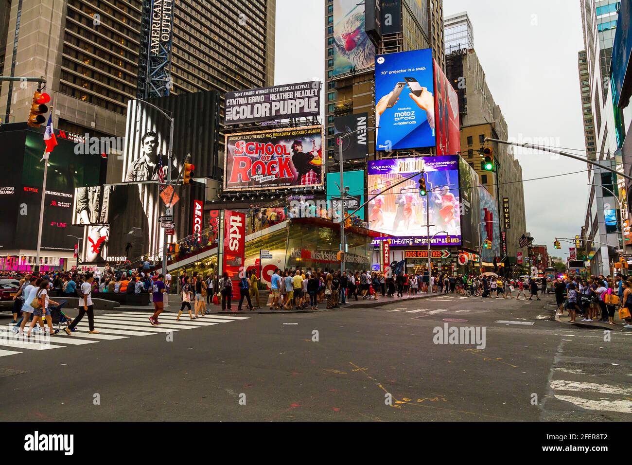 People crossing the street at Times Square on a busy summer evening Stock Photo