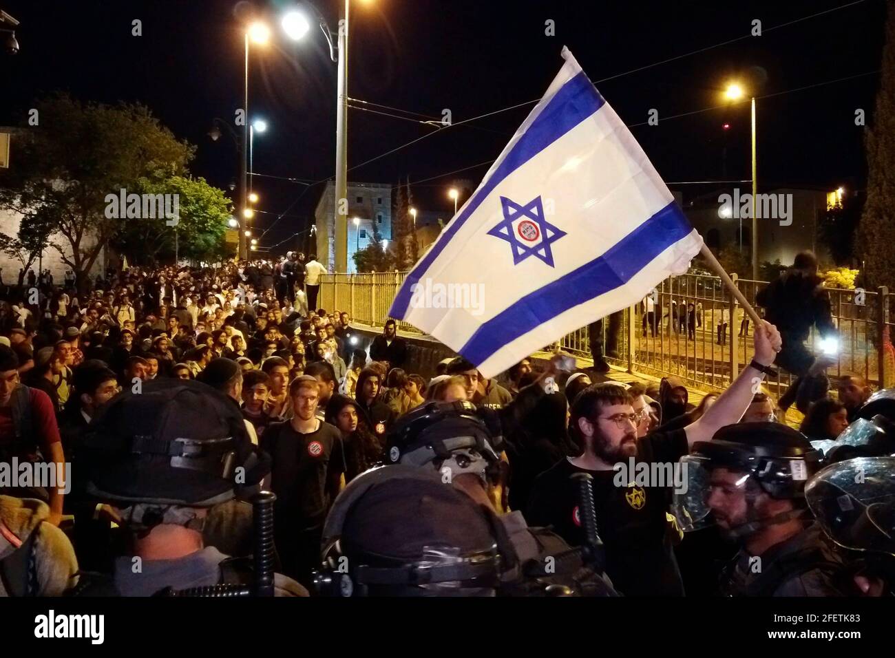 JERUSALEM, ISRAEL - APRIL 22: Israeli police officers confront far-right activists during a rally of Jewish Supremacists near the Old City on April 22, 2021, in Jerusalem, Israel. Hundreds of Jewish far-right activists marched from Jerusalem's Zion Square on Thursday's night toward the Old City in what the anti-assimilation group Lehava called a march to 'restore Jewish dignity.' The march comes after a week of violent assaults on Arab Israelis and Palestinian residents of central Jerusalem. Stock Photo