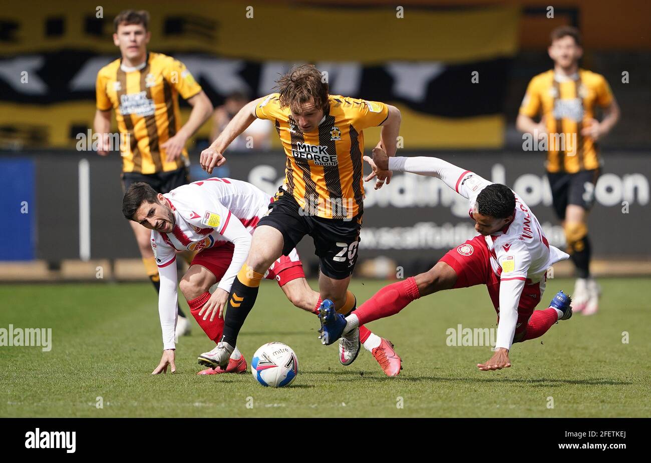 Cambridge United's Joe Ironside (centre) evades a tackle from Stevenage's Terence Vancooten (right) during the Sky Bet League Two match at Abbey Stadium, Cambridge. Picture date: Saturday April 24, 2021. Stock Photo