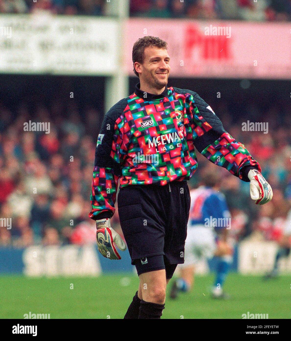 Tim Flowers Blackburn Rovers goalkeeper smiling and waving after winning a match against Southampton FC at the Dell wearing a very bright and colourful goalkeeping kit during the 1993-94 season.This image is bound by Dataco restrictions on how it can be used. EDITORIAL USE ONLY No use with unauthorised audio, video, data, fixture lists, club/league logos or “live” services. Online in-match use limited to 120 images, no video emulation. No use in betting, games or single club/league/player publications Stock Photo