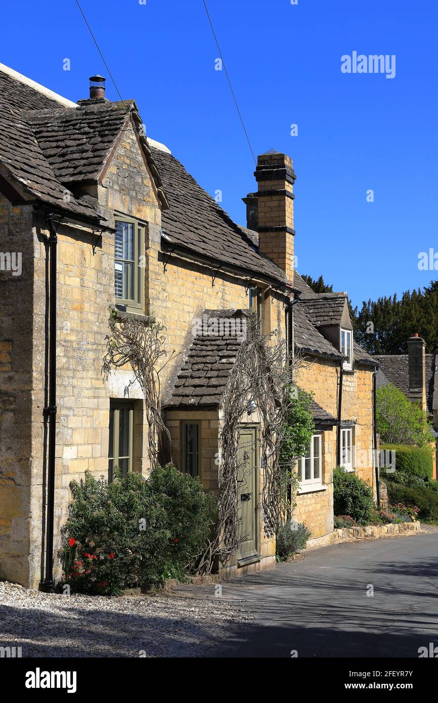 A row of traditionally built pretty Cotswold stone cottages in the Cotswold village of Withington in Gloucestershire Stock Photo