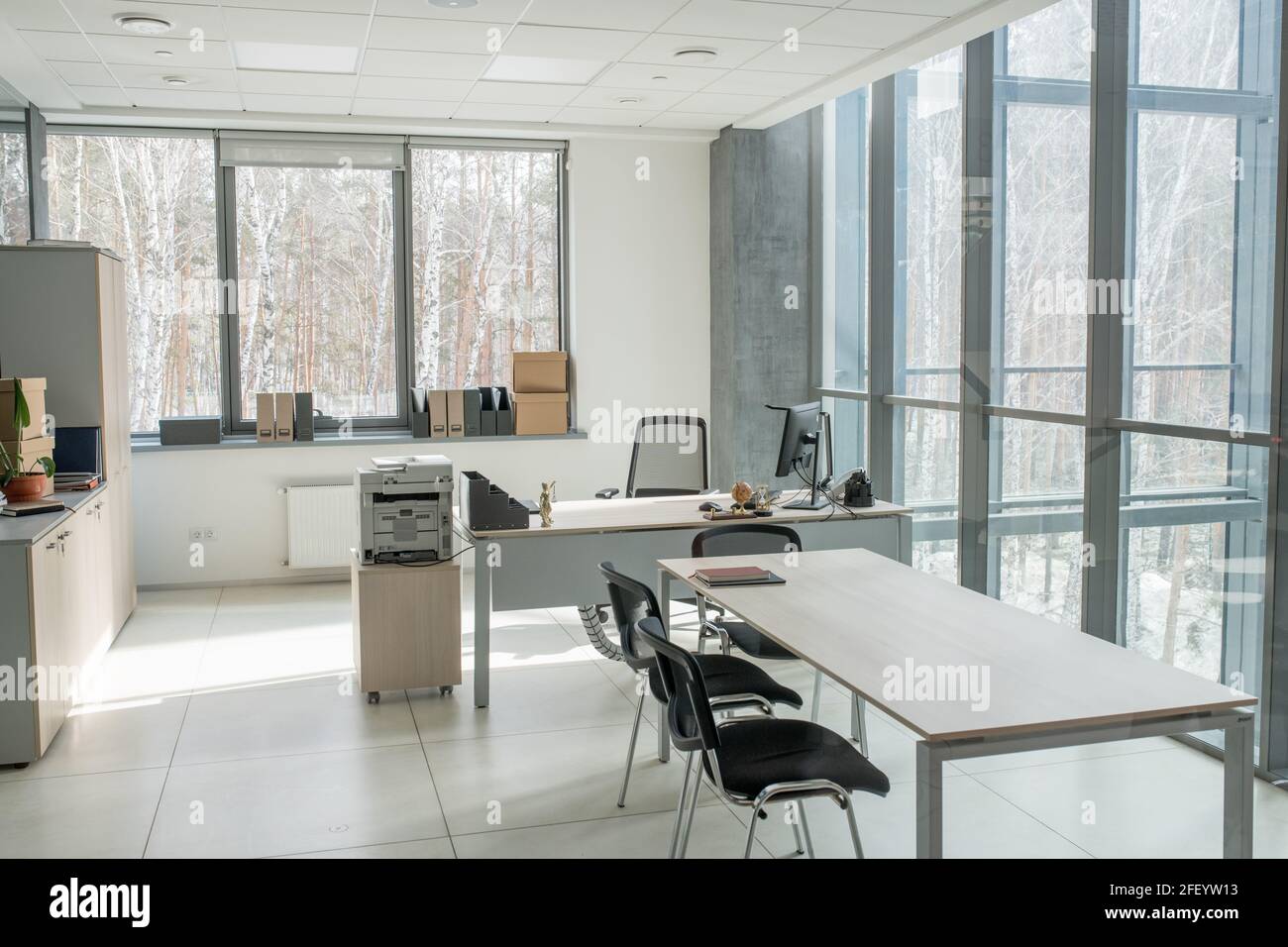 Small open space office with panoramic wall in business center: desk with  computer and scanner, long table for negotiation Stock Photo - Alamy