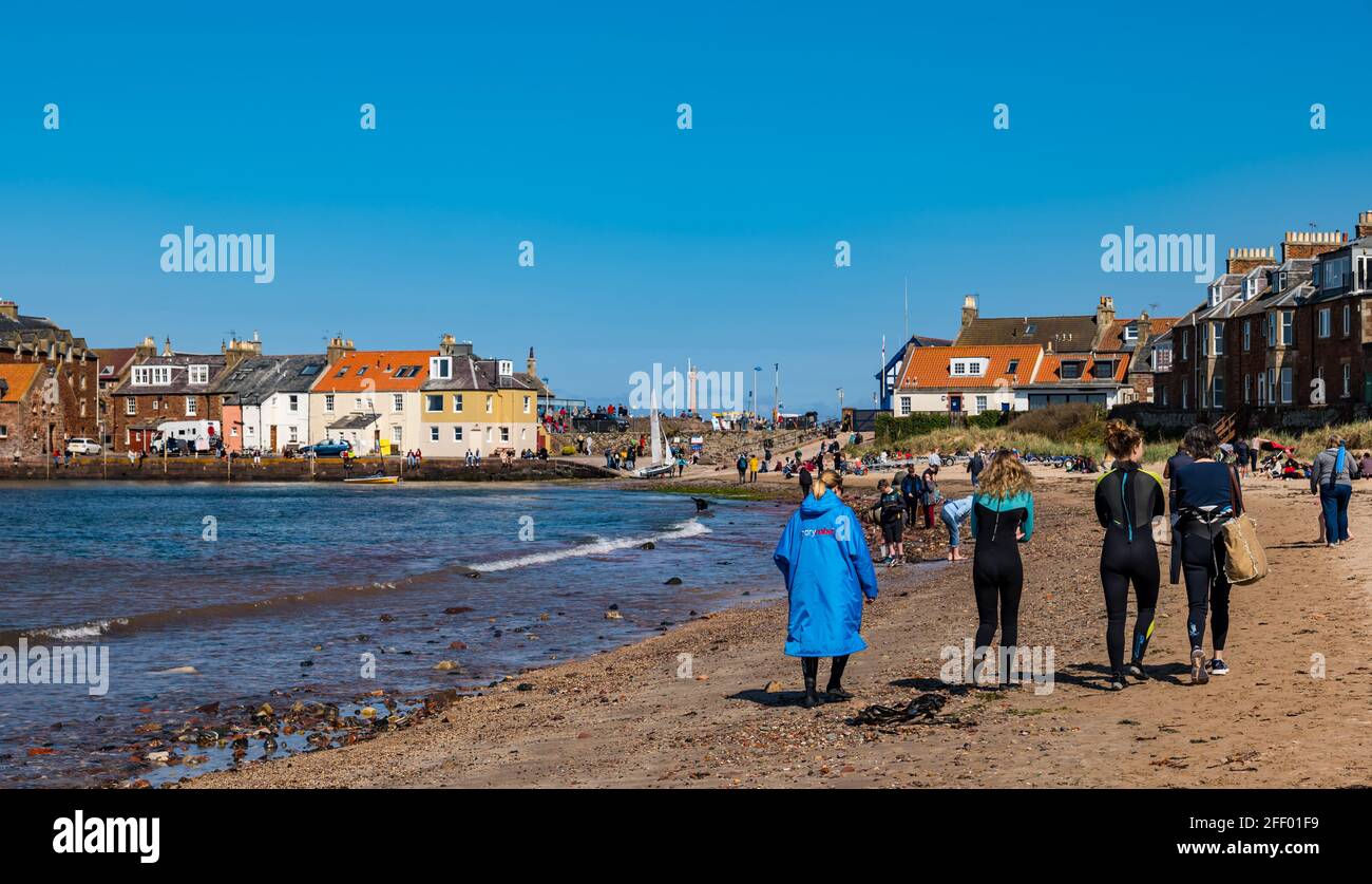 North Berwick, East Lothian, Scotland, United Kingdom, 24th April 2021. UK Weather: sunshine at the seaside: the sunny weather brings crowds to the seaside town despite the chilly breeze blowing in from the North Sea as people enjoy the easing of lockdown restrictions.  Pictured: People on West beach where it is a bit more sheltered from the wind. Stock Photo