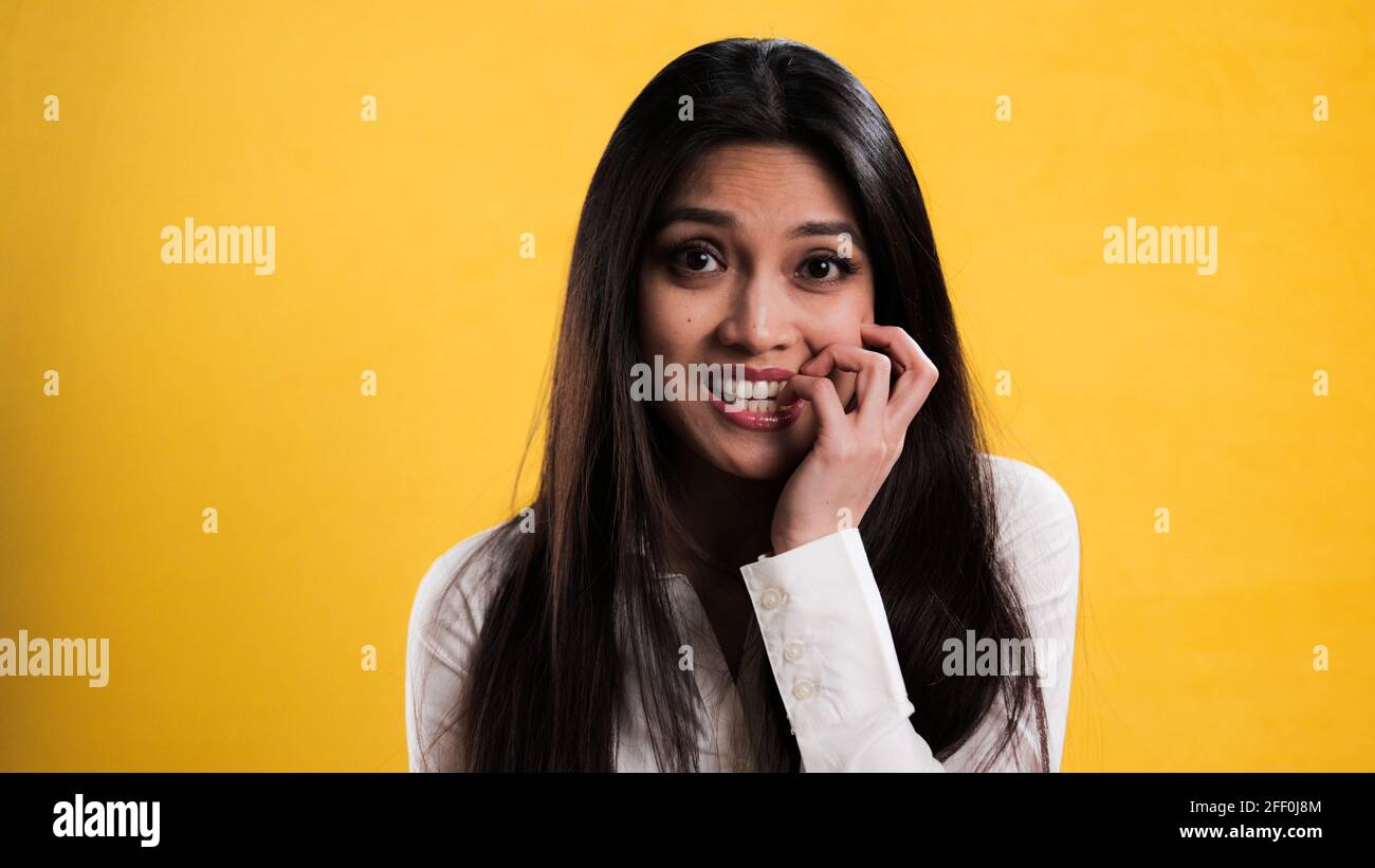 Young excited woman chews on her fingernails Stock Photo